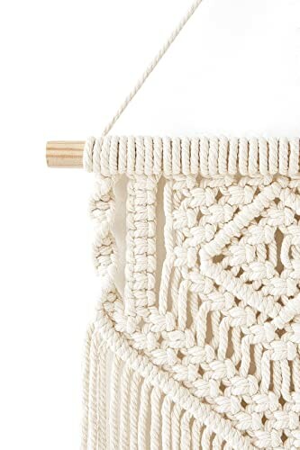 Close-up of a macrame wall hanging with intricate patterns.