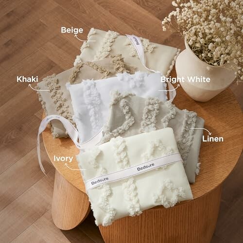 Assorted bedding samples labeled by color on a wooden table.