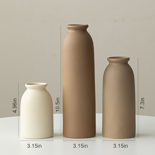 Three ceramic vases of varying heights on a table.