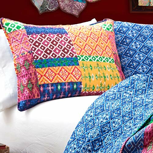 Colorful patchwork pillow and blue patterned bedding.