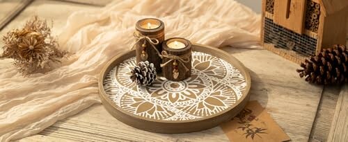 Decorative candles on a mandala tray with pinecones.