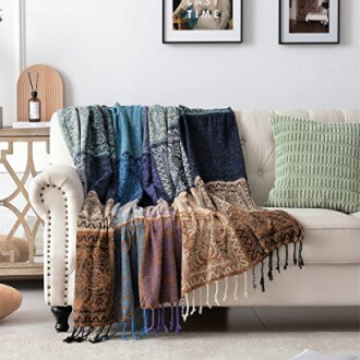 Colorful patterned throw blanket on a sofa with a green cushion.