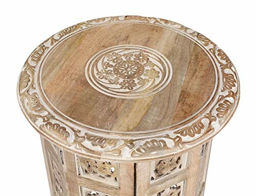 Intricately carved round wooden table with floral design.