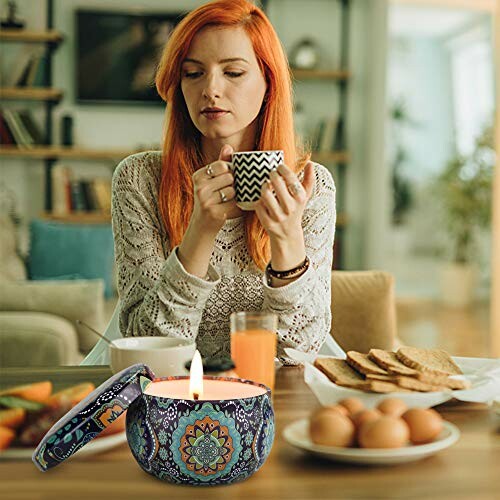 Woman drinking coffee at a table with a lit candle and breakfast items.